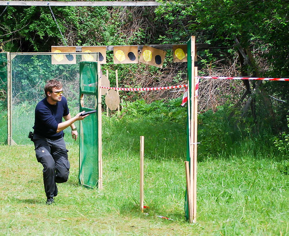 Tireur sportif en déplacement sur parcours dynamique avec pistolet lors d’une épreuve de tir de vitesse
