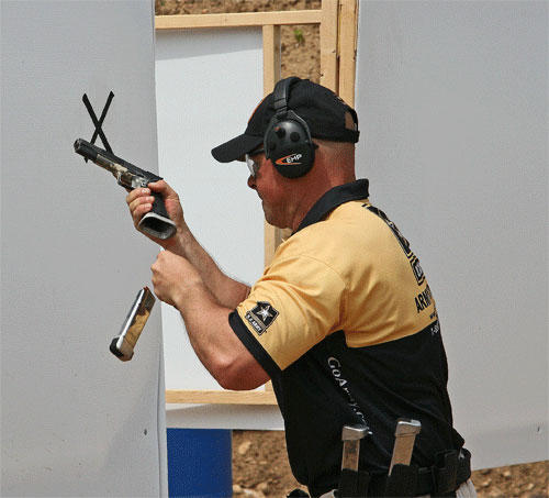 tireur en TSV effectuant un rechargement rapide avec pistolet et chargeur en mouvement